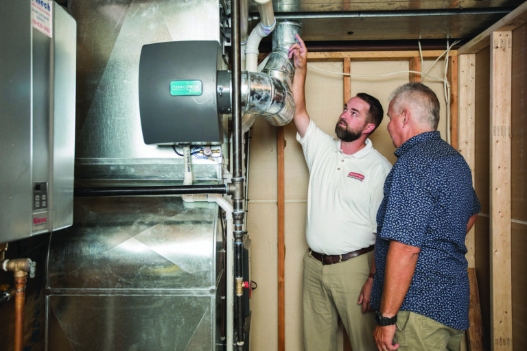 HVAC technician explaining a furnace installation to a homeowner