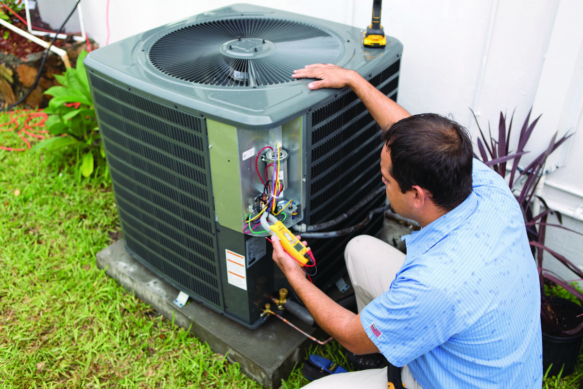 HVAC technician servicing an outdoor air conditioning condenser