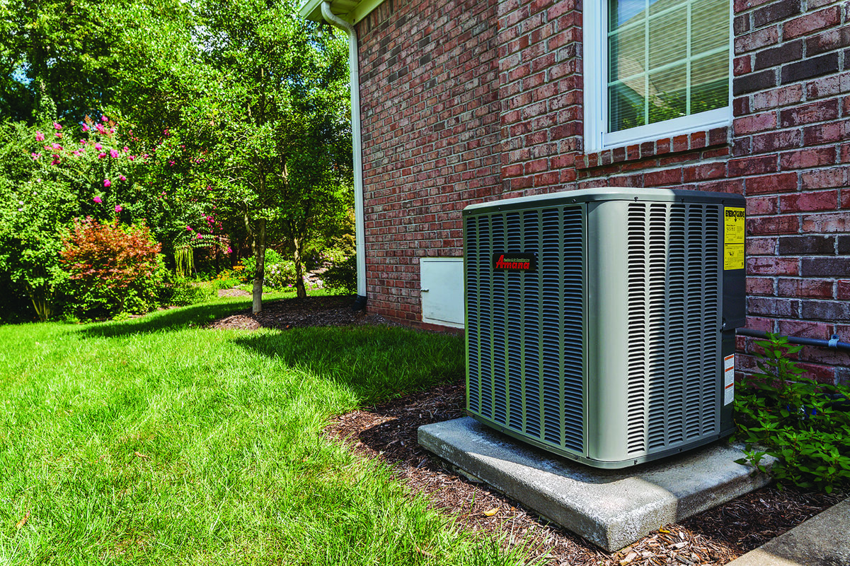 Amana outdoor air conditioning unit installed beside a brick home