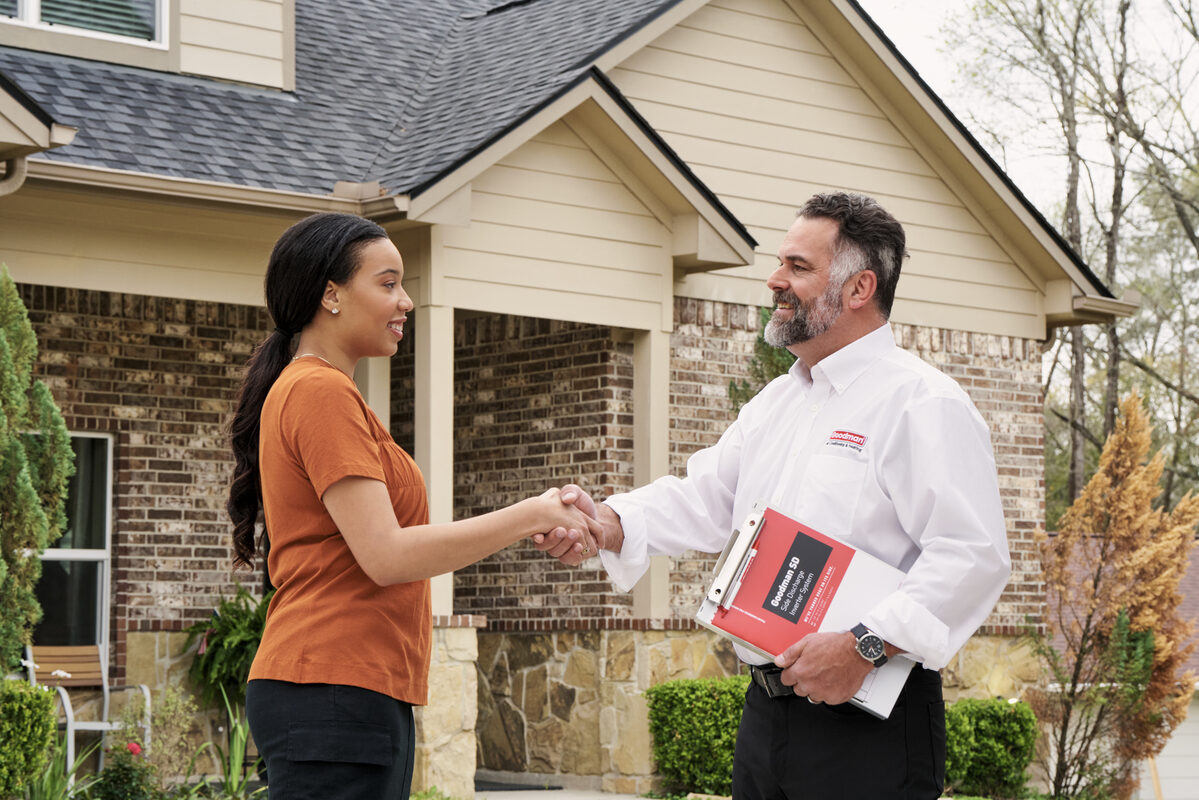 technician greeting a homeowner outside her home