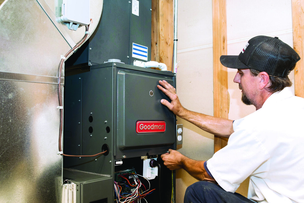 HVAC technician servicing an indoor furnace