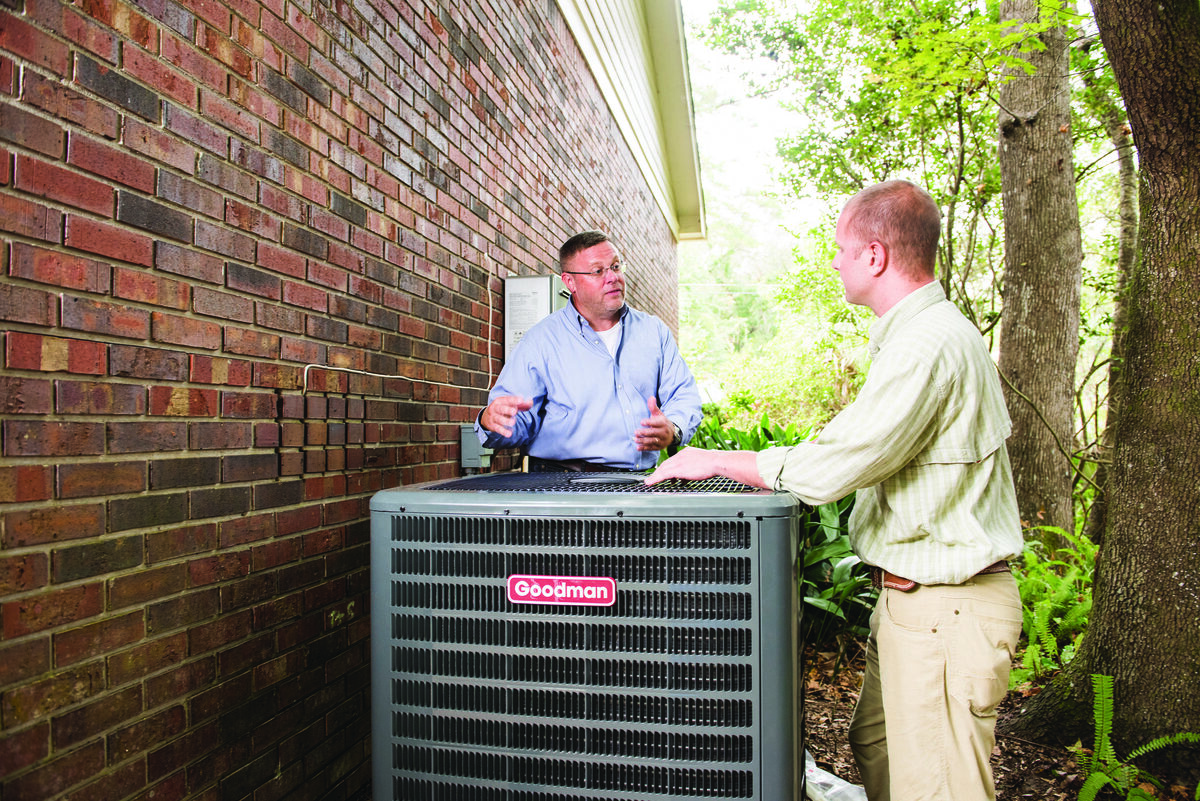 HVAC technician inspecting an outdoor air conditioning unit